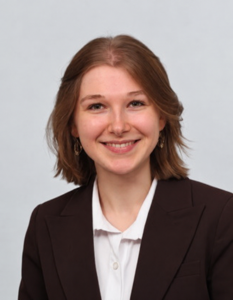 Portrait von Juma Jakopin vor grauem Hintergrund - LEYTBILD-Mitarbeiterin im Backoffice