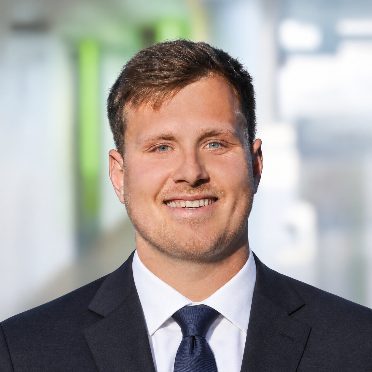 Portrait von Dominik Hermannspan vor LEYTBILD Hintergrund - LEYTBILD-Mitarbeiterin im Backoffice